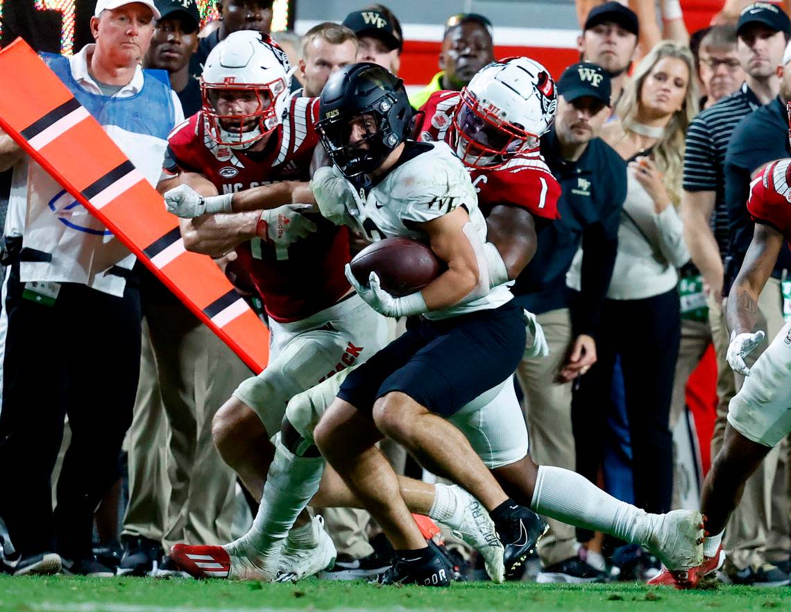 N.C. State’s Isaiah Moore (1) and Payton Wilson (11) stop Wake Forest wide receiver Taylor Morin (2) during the second half of N.C. State’s 30-21 victory over Wake Forest at Carter-Finley Stadium in Raleigh, N.C., Saturday, Nov. 5, 2022.