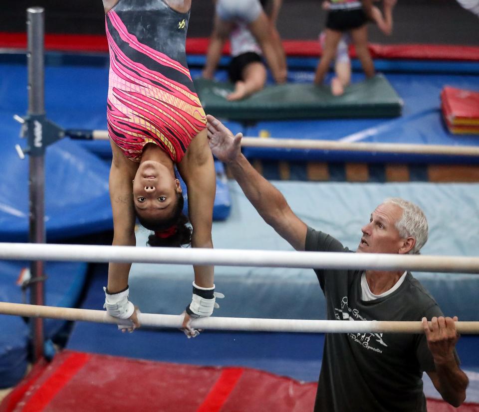 Coach Greg Mutchler works with gymnast Mya Wiley on the bars during practice at the Olympic Gymnastics Center in Silverdale on Aug. 2.
