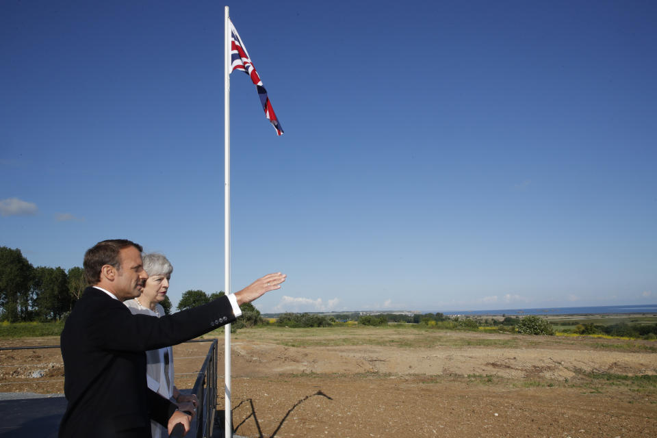 British Prime Minister Theresa May and French President Emmanuel Macron talk after a Franco-British ceremony marking the 75th anniversary of D-Day landings at Ver-Sur-Mer, Normandy, Thursday, June 6, 2019.(Philippe Wojazer/Pool via AP)