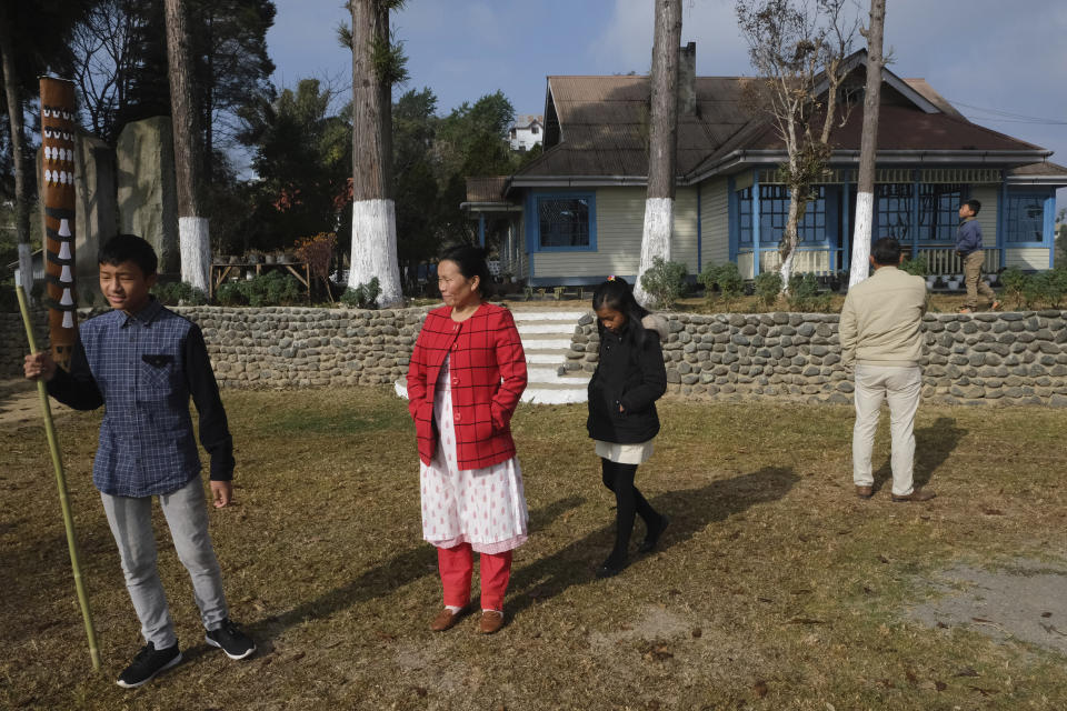 Nurse Shimray Wungreichon, 43, second left, stands in the lawn of the campus where her family lives, along with her husband and three children, a few hours before being administered the COVID-19 vaccine in Ukhrul, in the northeastern Indian state of Manipur, Saturday, Jan. 16, 2021. For the first three months after the pandemic arrived in her region, she couldn’t hug her three children, fearing she could potentially pass the virus to them. Her aged parents were to spend all of 2020 living with her, but it was too risky to live with a nurse so they moved back to their distant home village. And her anxiety spiked with every coronavirus test she conducted. (AP Photo/Yirmiyan Arthur)