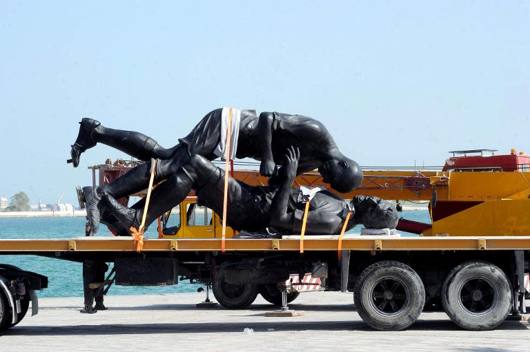 French Algerian born artist Adel Abdessemed's five-meter high (16.4-feet) “Coup de Tête” sculpture is seen loaded onto a lorry after being removed from Doha's corniche on October 30, 2013