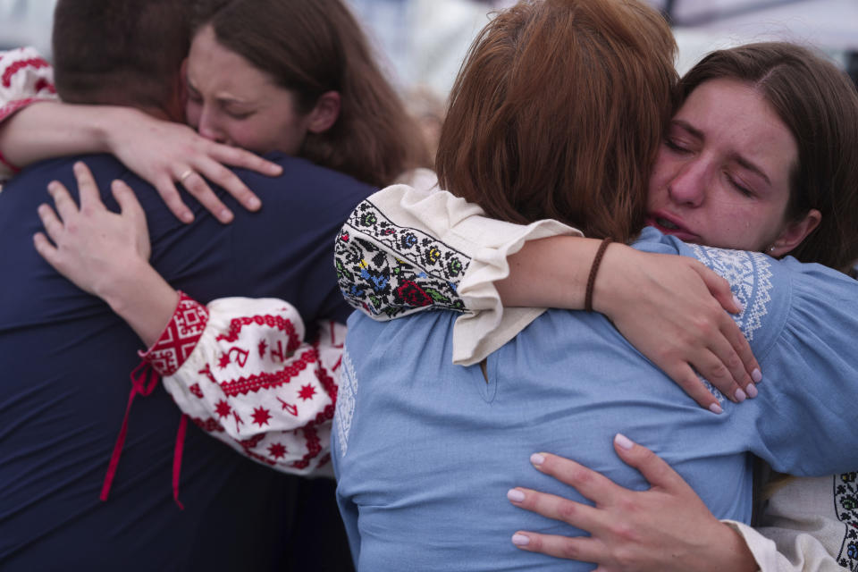 Women hug relatives of the Ukrainian journalist and volunteer combat medic Iryna Tsybukh during a memorial service on Independence square in Kyiv, Ukraine, Sunday, June 2, 2024. Nearly 1,000 people attended a ceremony Sunday honoring the memory of Ukrainian journalist Iryna Tsybukh, who was killed in action while serving as a combat medic a few days before her 26th birthday. Tsybukh was killed while on rotation in Kharkiv area, where Russia started its offensive nearly a month ago. (AP Photo/Evgeniy Maloletka)