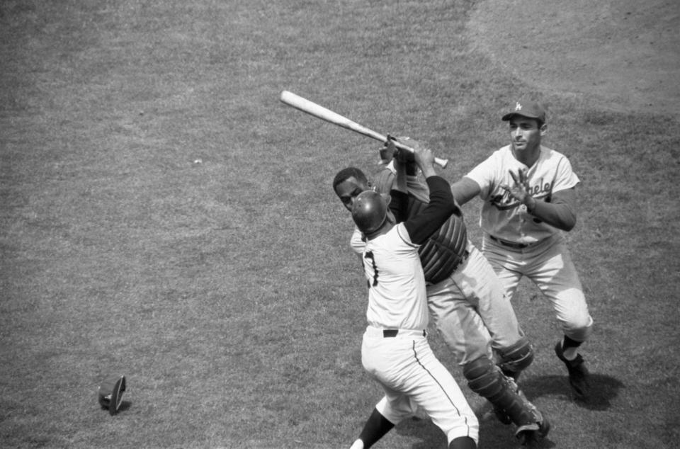 Juan Marichal, holding bat, attacked John Roseboro as Sandy Koufax closes in. (Getty Images)