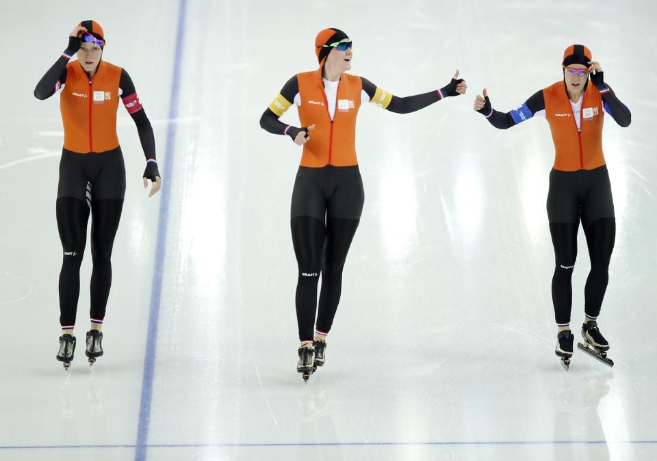 Jorien ter Mors, Lotte van Beek and Ireen Wust of the Netherlands congratulate each other after competing in the women's speedskating team pursuit quarterfinals at the Adler Arena Skating Center during the 2014 Winter Olympics in Sochi, Russia, Friday, Feb. 21, 2014. (AP Photo/Pavel Golovkin)