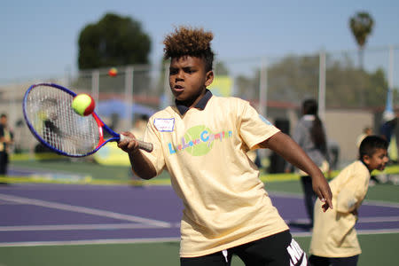 A boy hits a ball at a tennis workshop featuring U.S. Open Champion Sloane Stephens teaching tennis to 400 elementary students in Compton, California, U.S. April 12, 2018. REUTERS/Lucy Nicholson