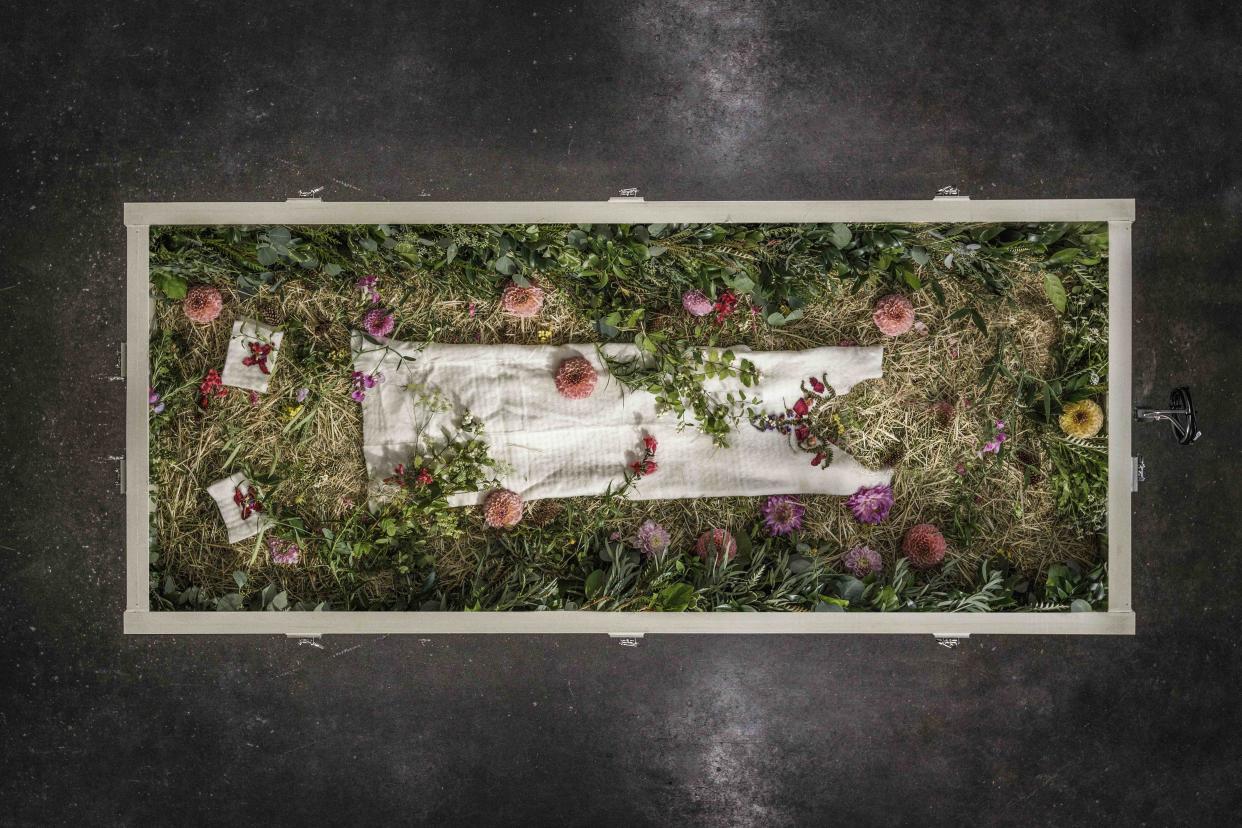 A human composting vessel with flowers is seen from above.