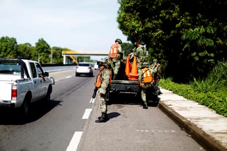 Military police officers remove a checkpoint from a road in Tuxtla Chico