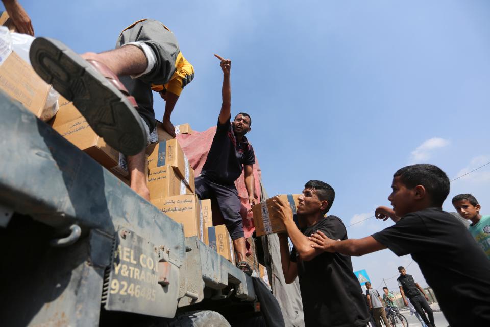 Palestinians loot a truck with humanitarian aid near the Rafah border crossing (AP)