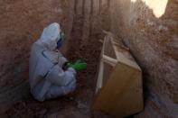 Members of the Popular Mobilization Forces (PMF) bury people who passed away due to coronavirus disease (COVID-19) at the new Wadi Al-Salam cemetery on the outskirts of the holy city of Najaf