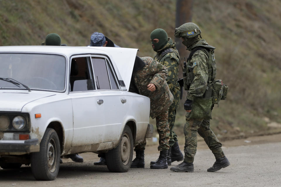 Russian peacekeepers check a car while patrolling an aria in Stepanakert, the separatist region of Nagorno-Karabakh, on Sunday, Nov. 15, 2020. Ethnic Armenian forces had controlled Nagorno-Karabakh and sizeable adjacent territories since the 1994 end of a separatist war. Fighting resumed in late September and have now ended with an agreement that calls for Azerbaijan to regain control of the outlying territories as well as allowing it to hold on to parts of Nagorno-Karabakh that it seized during the fighting. (AP Photo/Sergei Grits)