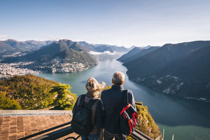 Two people overlooking mountains and water.