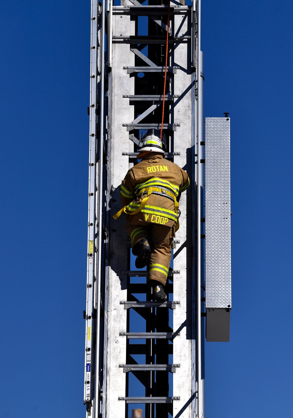 Rotan firefighter Vern Coop climbs 100 feet on an Abilene Fire Department ladder truck wearing his turnout gear at the department's training facility.