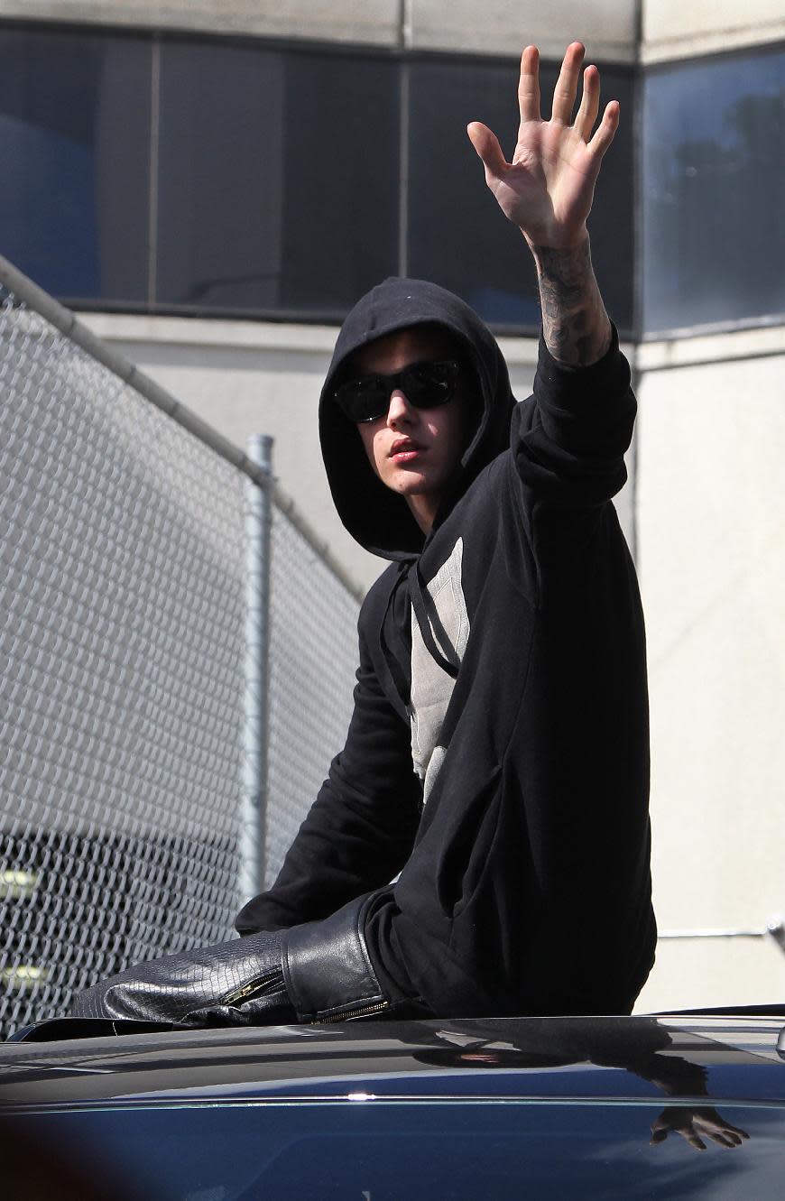 Singer Justin Bieber waves from atop an SUV as he leaves the Turner Guilford Knight Correctional Center, Thursday, Jan. 23, 2014, in Miami. Bieber was released from jail Thursday following his arrest on charges of driving under the influence, driving with an expired license and resisting arrest. Police say they stopped the 19-year-old pop star while he was drag-racing down a Miami Beach street before dawn. (AP Photo/El Nuevo Herald, Hector Gabino) FLORIDA KEYS OUT, MAGS OUT, NO SALES. DIARIO LAS AMERICAS OUT