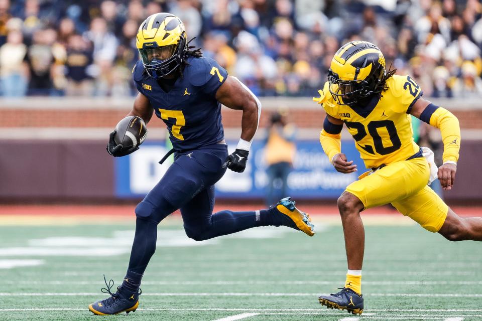 Blue Team running back Donovan Edwards (7) runs past Maize Team defensive back Jyaire Hill (20) during the first half of the spring game at Michigan Stadium in Ann Arbor on Saturday, April 20, 2024.