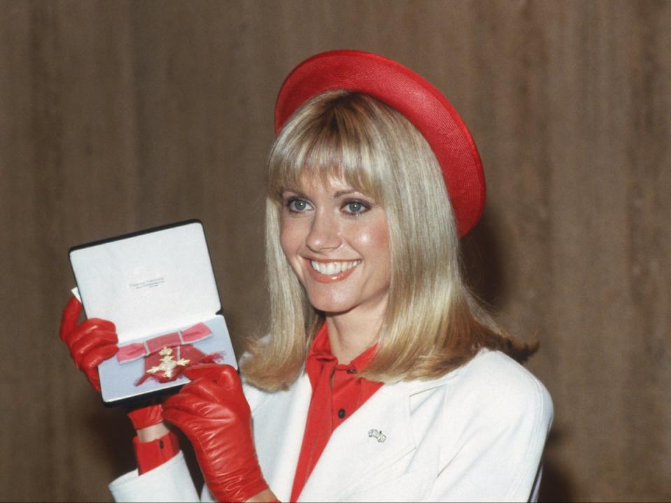 Newton-John receiving an OBE at Buckingham Palace in 1979. She was later made a Dame in 2020 for services to charity, cancer research and entertainment (Keystone/Hulton Archive/Getty Images)