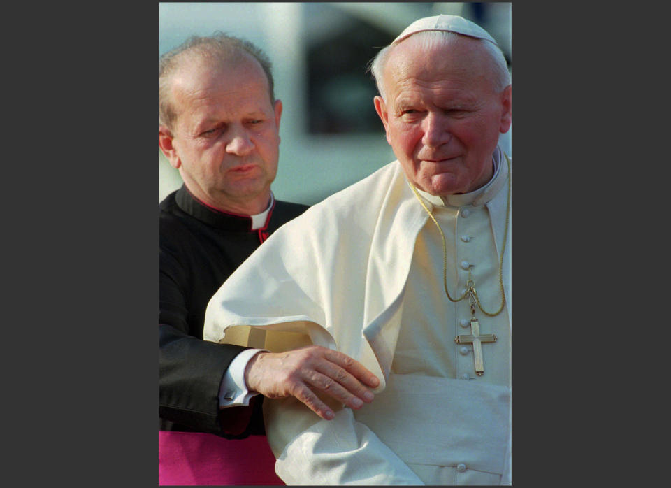 FILE - In this May 4, 1996 file photo, Pope John Paul II, right, is helped by his personal secretary, Stanislaw Dziwisz, as he arrives in Como, northern Italy, for a two day visit. Poles are divided between praise and condemnation of Pope John Paul II’s secretary over publishing the beloved pontiff’s personal notes against his last will and testament. John Paul ordered the notes burned after his death and put his trusted confidant, Dziwisz, in charge of the task. To everyone’s surprise, Dziwisz, now a cardinal, said recently that he “did not have the courage” to destroy the notes and is having them published as a precious insight into the inner life of the pope. (AP Photo/Luca Bruno, File)