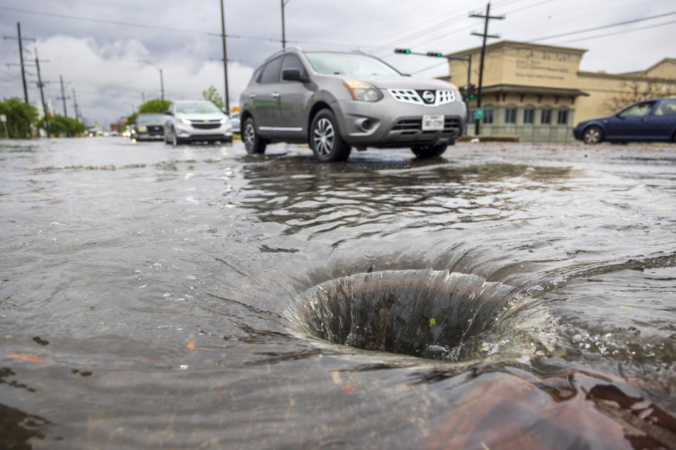 A whirlpool of water in the middle of a street after a manhole cover was pushed away from a rush of water moving across Broad Street during a heavy downpour in New Orleans, Wednesday, April 10, 2024. (Chris Granger/The Times-Picayune/The New Orleans Advocate via AP)