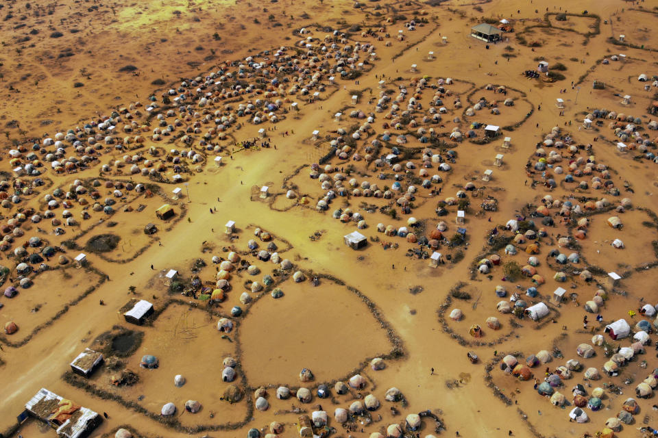 Huts made of branches and cloth provide shelter to Somalis displaced by drought on the outskirts of Dollow, Somalia on Monday, Sept. 19, 2022. Somalia has long known droughts, but the climate shocks are now coming more frequently, leaving less room to recover and prepare for the next. (AP Photo/Jerome Delay)