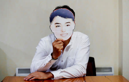 Hong Ryong Su, an ethic Korean in Japan, poses with a face cut-out which North Korea's cheerleaders used in the Pyeongchang 2018 Winter Olympics, at his house in Tokyo Japan, June 3, 2018. Hong said he downloaded the image from the internet and made the cut-out himself after seeing it broadcast from the Olympic Games. REUTERS/Kim Kyung-Hoon