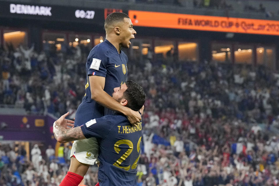 France's Kylian Mbappe celebrates with teammate Theo Hernandez after scoring his side's opening goal against Denmark during a World Cup group D soccer match at the Stadium 974 in Doha, Qatar, Saturday, Nov. 26, 2022. (AP Photo/Martin Meissner)