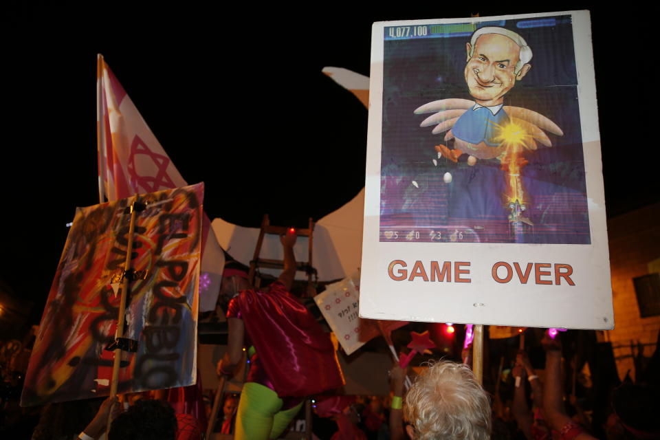 Thousands protest against Israel's Prime Minister Benjamin Netanyahu in front of his official residence in Jerusalem, Saturday, Aug. 8, 2020. (AP Photo/Ariel Schalit)