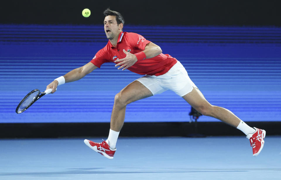 Serbia's Novak Djokovic makes a forehand return to Germany's Alexander Zverev during their ATP Cup match in Melbourne, Australia, Friday, Feb. 5, 2021.(AP Photo/Hamish Blair)