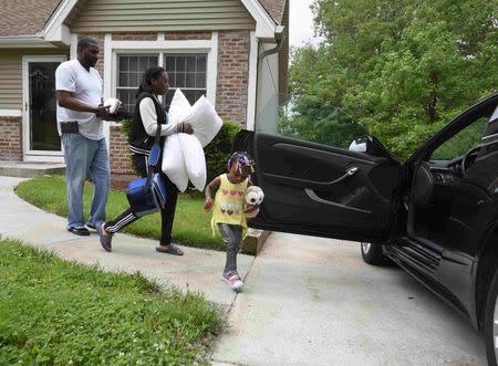 Auto worker Jermaine Austin (L), who works for General Motors, gets some help packing his car from daughters Niya, 17, and Jayla, 2, as he prepares to leaves to a new job in Texas for an unknown duration in Kansas City, Missouri May 16, 2015. REUTERS/Ed Zurga