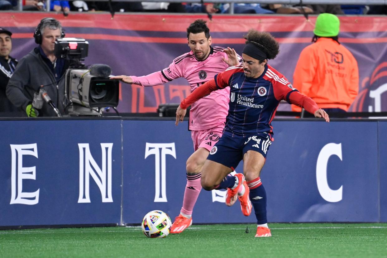 New England Revolution midfielder Ryan Spaulding, right, and Inter Miami CF midfielder Lionel Messi battle for the ball during the second half Saturday night.