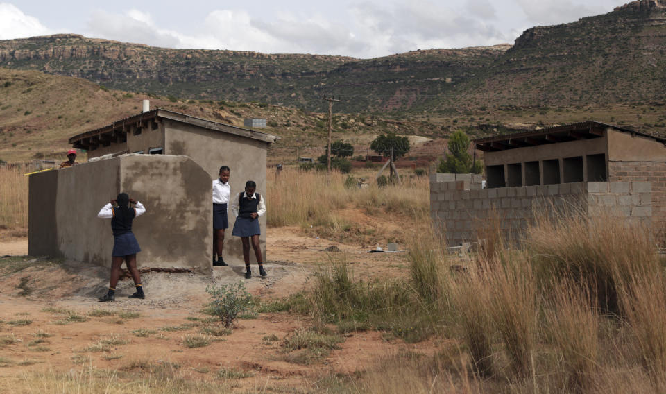 Girls stand near a pit latrine, at a school in Ghoboshiyane village, South Africa, Wednesday, March 17, 2021. A school headmaster in South Africa has been arrested and charged with child abuse after lowering an 11-year-old student into a pit latrine to search for the official’s cellphone. According to local news reports, the headmaster of Luthuthu Junior Secondary School in the Eastern Cape province has been released on bail. (AP Photo)