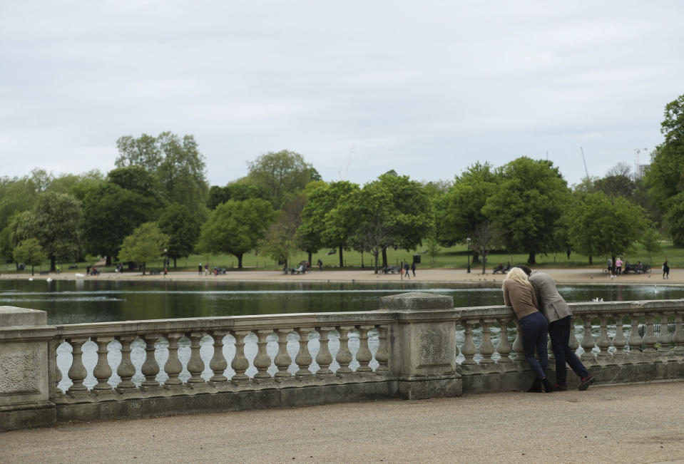 People in a sparsely populated Hyde Park, with the Serpentine lake, in central London, as the UK continues in lockdown to help curb the spread of the coronavirus, Sunday May 3, 2020. The highly contagious COVID-19 coronavirus has impacted on nations around the globe, many imposing self isolation and exercising social distancing when people move from their homes. (Yui Mok / PA via AP)