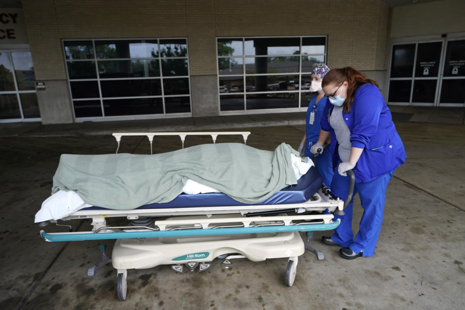 Medical staff pause as they move the body of a COVID-19 patient who died to a loading dock to hand off to a funeral home van, at the Willis-Knighton Medical Center in Shreveport, La., Wednesday, Aug. 18, 2021. (AP Photo/Gerald Herbert)