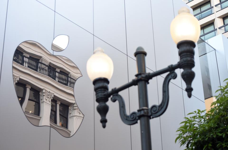 An old San Francisco building is reflected inside the glossy Apple store logo