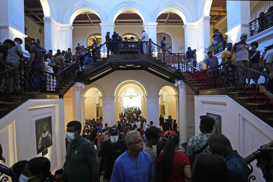 Protesters look around at the president's official residence a day after it was stormed in Colombo, Sri Lanka, Sunday, July 10, 2022. Sri Lanka’s opposition political parties will meet Sunday to agree on a new government a day after the country’s president and prime minister offered to resign in the country’s most chaotic day in months of political turmoil, with protesters storming both officials’ homes and setting fire to one of the buildings in a rage over the nation’s economic crisis. (AP Photo/Eranga Jayawardena)