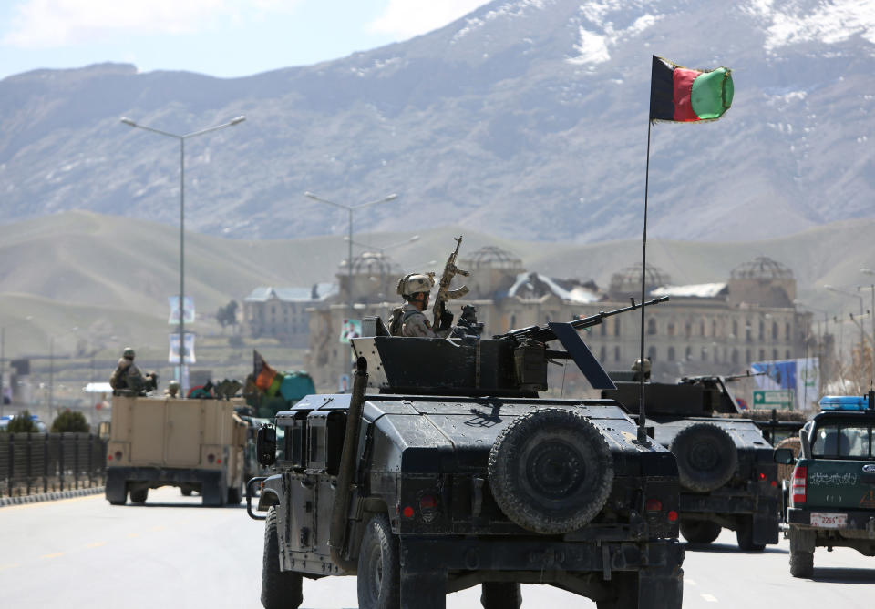 Afghan security officers arrive to the scene after two suicide bombers have struck near the home of candidate running for president, Ashraf Ghani Ahmadzai in the country's April 5 elections, in Kabul, Afghanistan, Tuesday, March 25, 2014. An Afghan police official said two suicide bombers were dead but another four insurgents may still be inside the election commission office. Witnesses reported heavy gunfire and scores of heavily armed troops with Afghanistan’s rapid response force had surrounded the building, located near the home of Ahmadzai (AP Photo/Rahmat Gul)