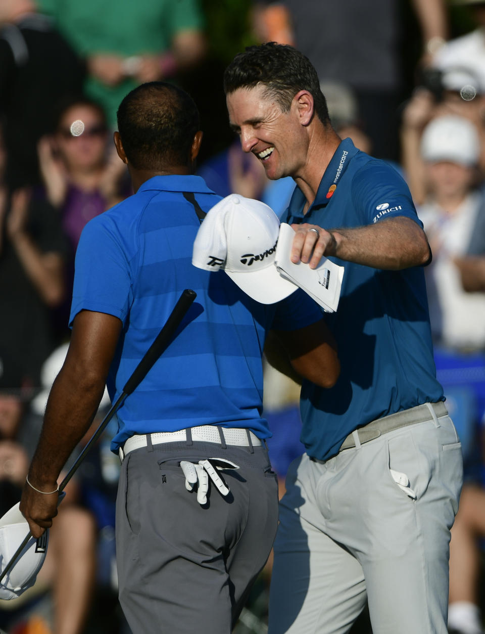 Justin Rose congratulates Tiger Woods, on his third round finish in the Tour Championship golf tournament Saturday, Sept. 22, 2018, in Atlanta. Woods maintained the lead with a 12 under par. (AP Photo/John Amis)