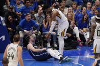 Dallas Mavericks guard Luka Doncic (77) lies on the court after he took a hard foul from Utah Jazz center Hassan Whiteside, right, during the second half of Game 5 of an NBA basketball first-round playoff series, Monday, April 25, 2022, in Dallas. (AP Photo/Tony Gutierrez)