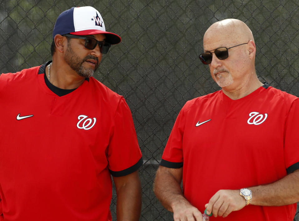 FILE - In this Feb. 17, 2020, file photo, Washington Nationals manager Dave Martinez, left, talks with general manager Mike Rizzo during spring training baseball practice in West Palm Beach, Fla. Armed with a new multiyear contract, Rizzo says his top priority is working on a new deal for Martinez. The team has a club option for Martinez for 2021, but Rizzo says he prefers a long-term deal for the manager. (AP Photo/Jeff Roberson, File)