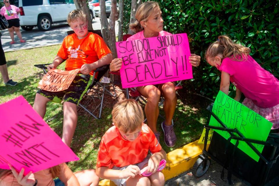 Jessica Stanley, center, and her four children sit outside the Jackson County Courthouse in Pascagoula on Thursday, July 18, 2024, as Heather Wyatt participates in a hearing over her social media in chancery court.