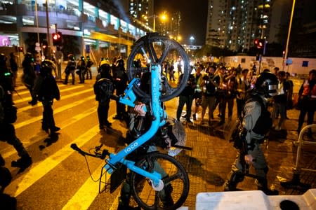 Riot police officers remove a barricade set up by anti-government protesters during a protest at Tseung Kwan O district, in Hong Kong,