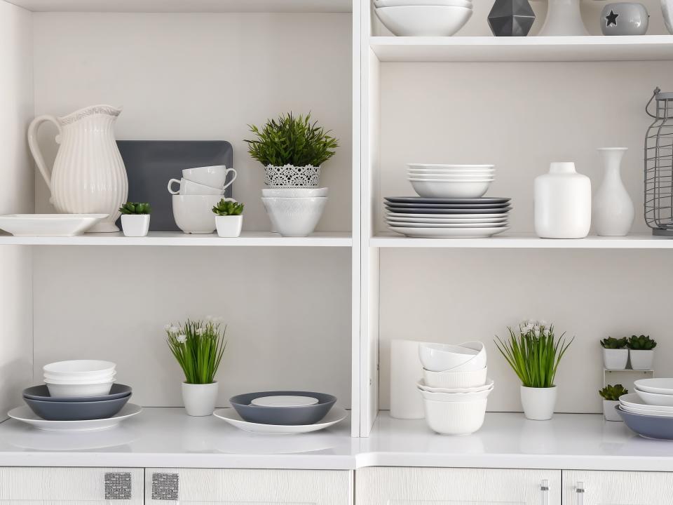 White kitchen open shelving with cups, plates, and vases