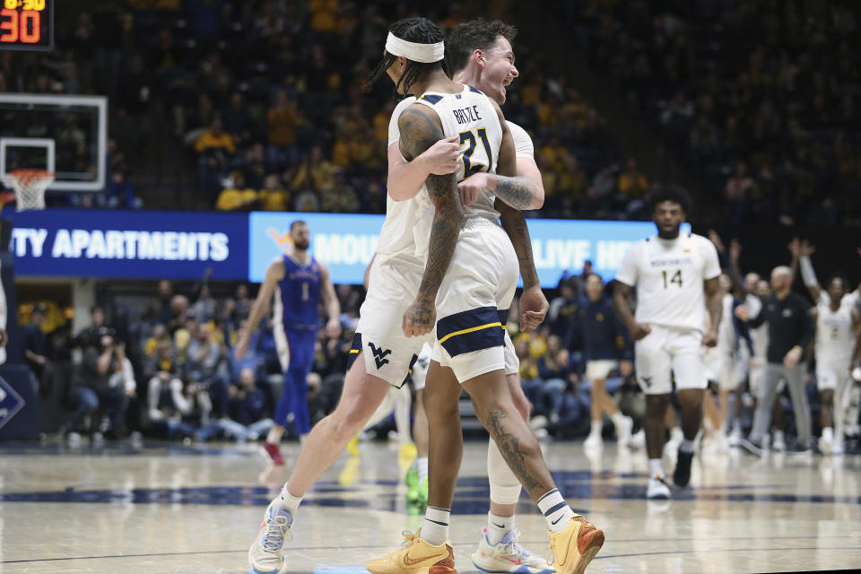 West Virginia guard RaeQuan Battle (21) and forward Quinn Slazinski (11) celebrate during the second half of an NCAA college basketball game against Kansas, Saturday, Jan. 20, 2024, in Morgantown, W.Va. (AP Photo/Kathleen Batten)