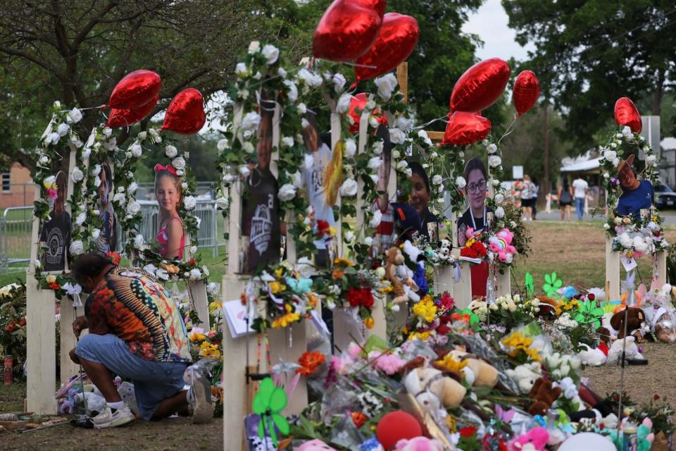 PHOTO: A man places a candle on a memorial for the 19 children and two adults killed on May 24th during a mass shooting at Robb Elementary School in Uvalde, TX, May 30, 2022. (Michael M. Santiago/Getty Images)