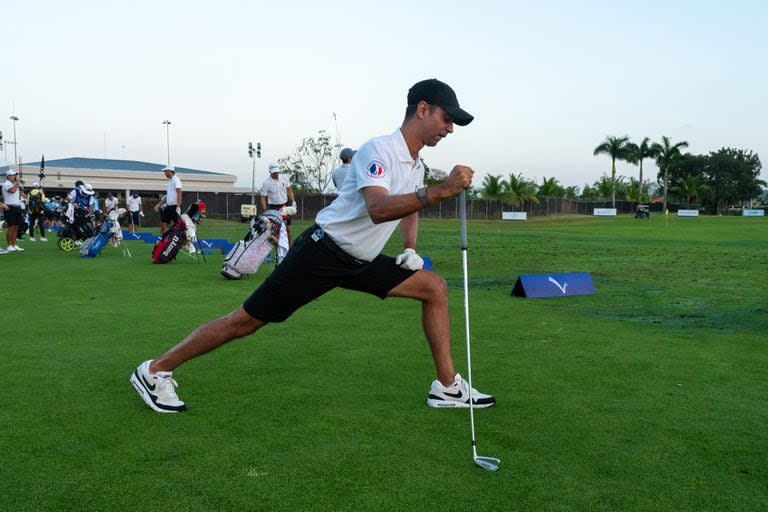 Miguel Ordoñez elonga antes de comenzar la práctica, mientras otros golfistas ya prueban sus primeros tiros