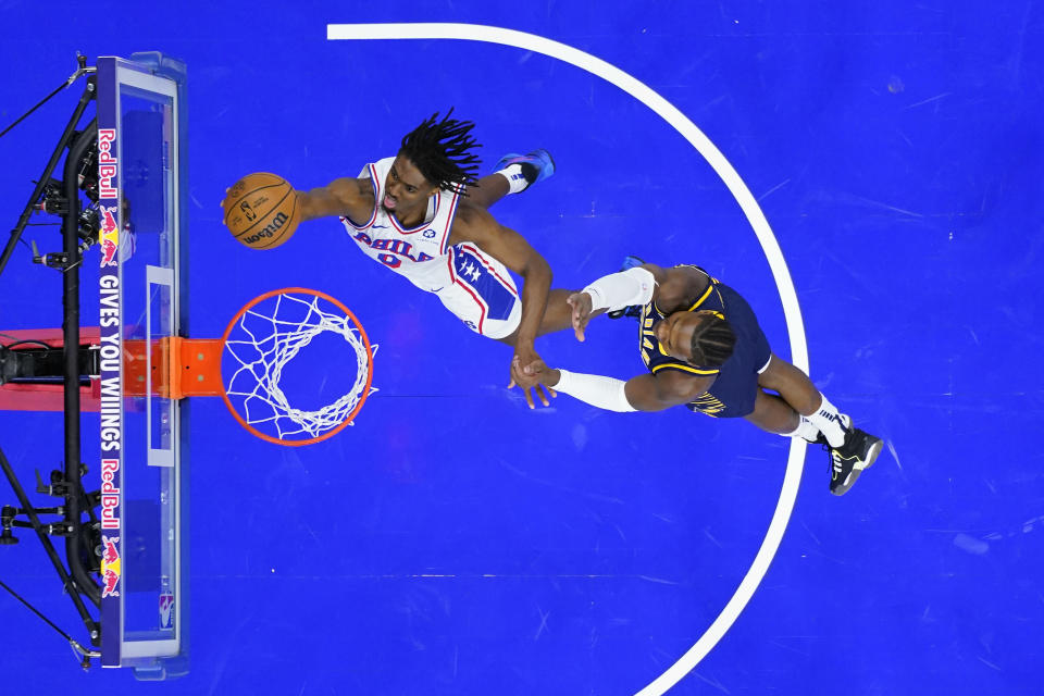 Philadelphia 76ers' Tyrese Maxey, left, goes up for a shot past Indiana Pacers' Bennedict Mathurin during the first half of an NBA basketball game, Sunday, Nov. 12, 2023, in Philadelphia. (AP Photo/Matt Slocum)