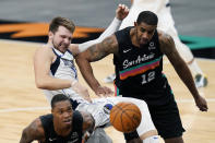 Dallas Mavericks guard Luka Doncic, center, battles San Antonio Spurs center LaMarcus Aldridge (12) and guard Lonnie Walker IV, left, for a rebound during the second half of an NBA basketball game in San Antonio, Friday, Jan. 22, 2021. (AP Photo/Eric Gay)