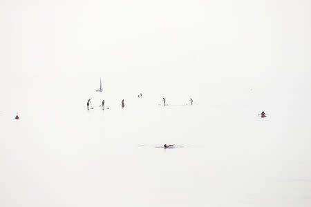 Beachgoers enjoy the Mediterranean Sea in Tel Aviv, Israel April 9, 2016. The picture was created by exposing for the shadows on a hazy day. REUTERS/Baz Ratner