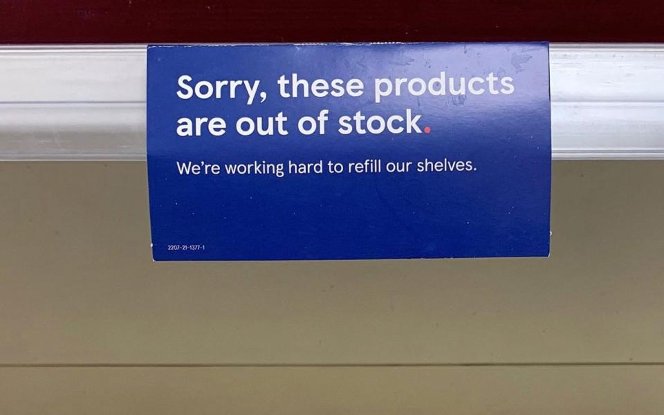 A sign apologising to customers for a lack of stock is pictured above an empty Tesco shelf