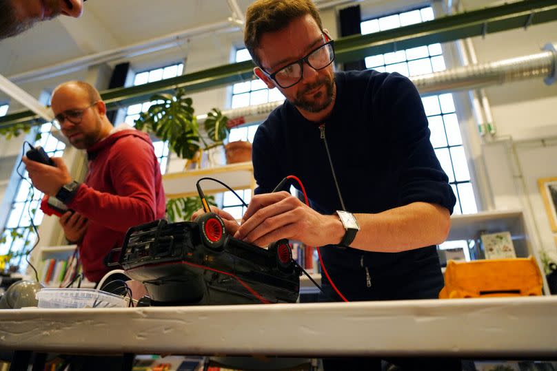 A volunteer repairs a remote control toy truck at a fortnightly repair cafe event in Malmo, November 2021