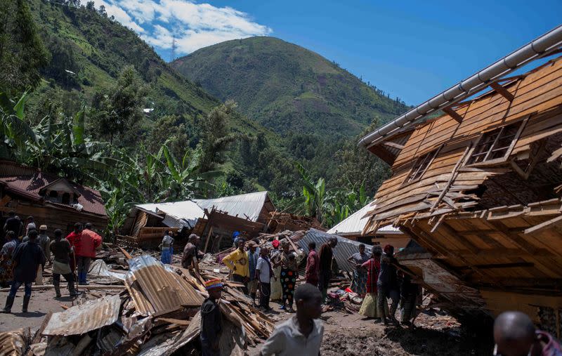 FILE PHOTO: Congolese civilians gather after the death of their family members following rains that destroyed buildings and forced aid workers to gather mud-clad corpses into piles in the village of Nyamukubi