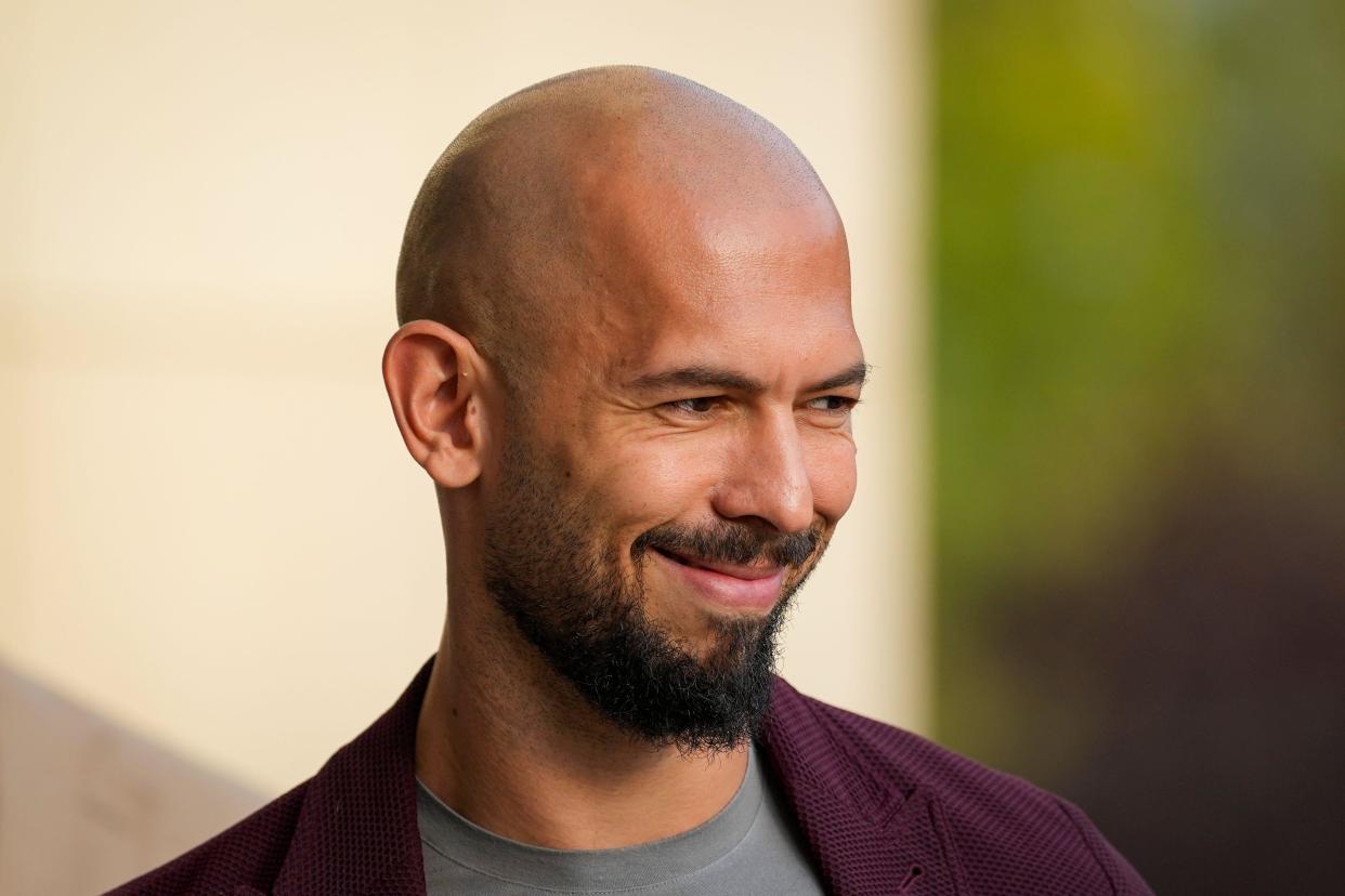 Andrew Tate smiles as he exits the Bucharest Tribunal in Bucharest, Romania, Friday, Nov. 3, 2023. The Tate brothers, Andrew and Tristan, both facing human trafficking charges in Romania, appeared in court to ask for changes in the current judicial measures imposed on them, as well as lifting of measures that saw a number of their assets seized during investigations.(AP Photo/Andreea Alexandru)